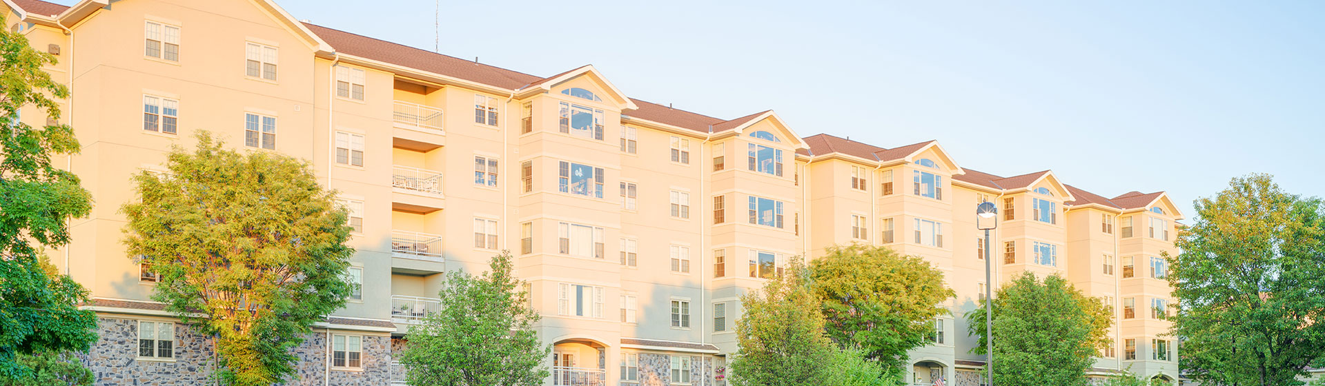 Apartments with sun shining on them and balconies and big windows